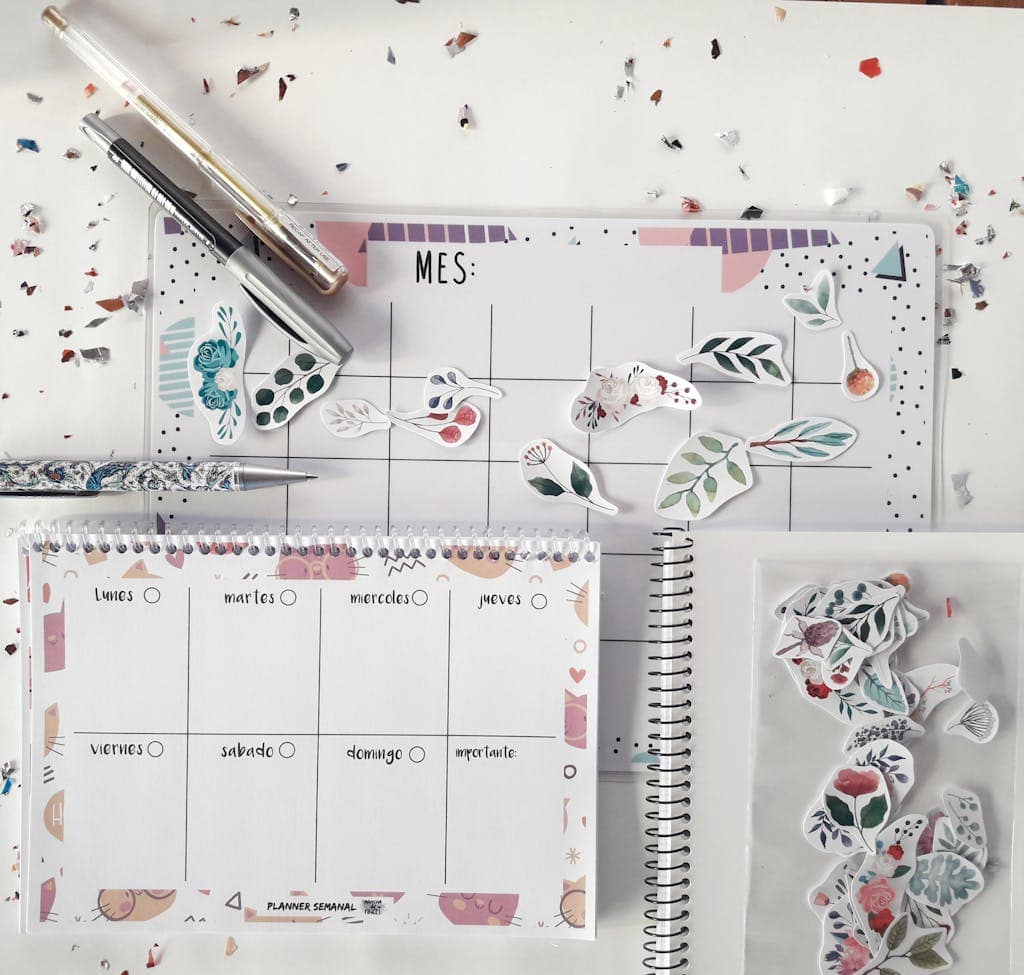 Flat lay of a planner with decorative stickers and stationery for organizing tasks creatively.